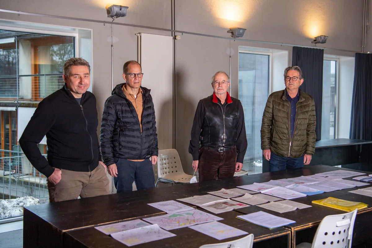 Vier Männer der Gruppe Echolot vor einem Tisch.